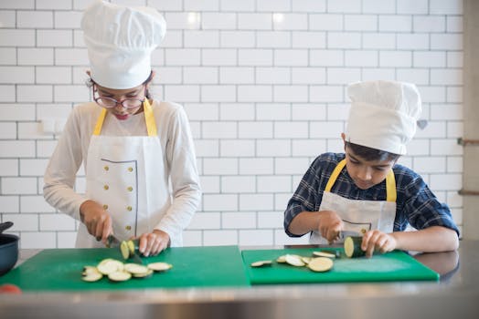 a child using a plastic knife to cut vegetables